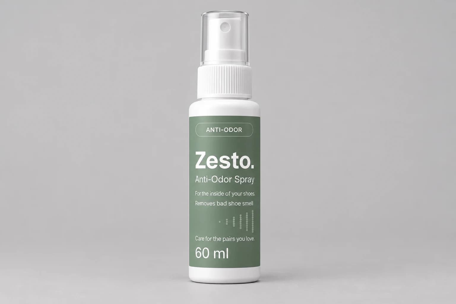 Flacon de spray anti-odeur Zesto. 60 ml avec capuchon transparent et étiquette verte, sur fond gris clair.